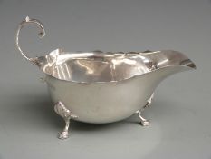 George V hallmarked silver sauce boat with shaped edge, raised on three feet, Chester 1930 maker