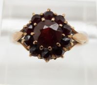 A 9ct gold ring set with an oval cut ruby surrounded by diamonds, 3.7g, size M