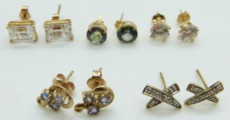 Two pairs of 14k gold studs/ earrings set with cubic zirconia, a pair of 14k gold studs set with