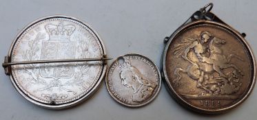 Three Victorian silver coins, comprising two crowns in mounts and a pierced Jubilee shilling