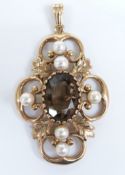 A 9ct gold pendant in a scrolling foliate design set within an oval cut smoky quartz and cultured