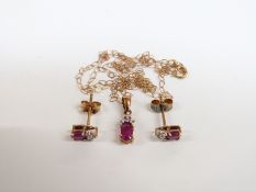 A 9ct gold necklace set with a ruby and diamond, with matching earrings