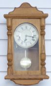 Light oak three train German wall clock with Roman dial, striking the quarters on chimes, 50cm tall