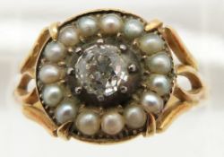 An early Victorian ring set with an old cut diamond of approximately 0.35ct surrounded by seed