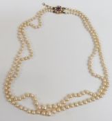 A double strand of cultured pearls with a 9ct gold clasp set with an amethyst