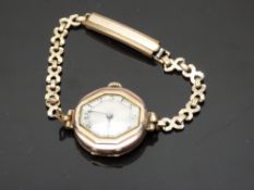 9ct gold ladies wristwatch with blued hands, black Arabic numerals, silver dial, bevelled bezel
