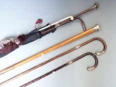 Five hallmarked silver mounted walking sticks and canes including malacca, military swagger stick