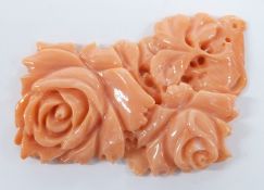 A carved coral plaque depicting roses, 4 x 2.5cm