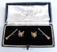 A pair of Victorian cufflinks in the form of fox's heads and hunting horns, set with sapphire eyes