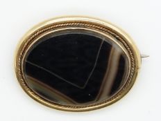 Victorian yellow metal brooch set with agate within a rope twist border, 11.5g, 3.6 x 3cm