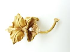 A 9k gold brooch in the form of a lily set with a pearl to the centre, 11.9g (5.7 x 3.2cm)