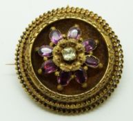 Victorian brooch set with foiled garnets and a paste stone to the centre within a border with