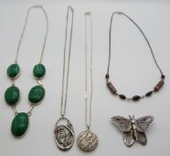 A silver necklace set with malachite cabochons, three silver necklaces and a silver butterfly