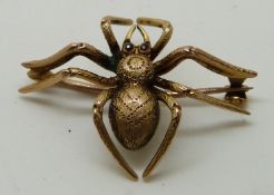 9ct gold brooch in the form of a spider with textured body set with ruby eyes, 3.2g