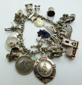 A silver charm bracelet with 20 charms including a fob, church, scooter, etc