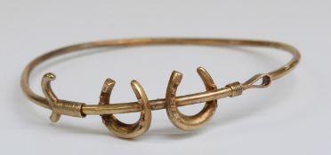 Edwardian bangle in the form of horseshoes and and crop marked 15ct gold, 4.6g, 5.6 x 5.2cm