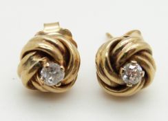 A pair of knot earrings set with a diamond measuring approximately 0.1ct to each, 1.6g