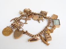 A 9ct gold charm bracelet set with a 1914 gold half sovereign, a horseshoe charm/pendant, locket,