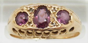 An 18ct gold ring set with three garnets, Birmingham 1919, in original box, 2.6g, size O