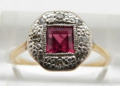 An 18ct gold ring set with a square cut ruby and diamonds in a platinum setting, 2.5g, size N
