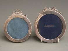 Two matching Edward VII circular hallmarked silver photograph frames with bow decoration to tops,