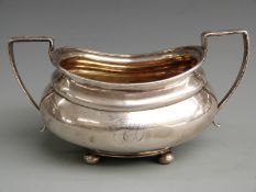 Georgian hallmarked silver twin handled sugar bowl with gilt wash interior, raised on four ball
