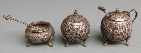 Indian or similar white metal three piece cruet with embossed decoration, height approximately