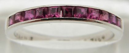 An 18ct white gold half eternity ring set with square cut rubies, 2.8g, size P