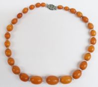 Baltic amber necklace of 28 graduated oval beads, the largest 21.2x15.5mm, interspersed with faceted