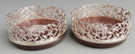 Pair of modern hallmarked silver wine coasters with pierced floral and foliate decoration, London