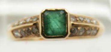A yellow metal ring set with an emerald cut emerald and diamonds to the shoulders, 2.2g, size P