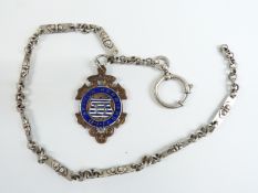 A silver watch chain with a hallmarked silver and 9ct gold fob set with enamel reading 'Sefton