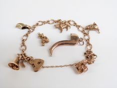 A 9ct gold charm bracelet, with charms including 14k gold bell, 9ct gold cow, 9ct gold cat and a 9ct