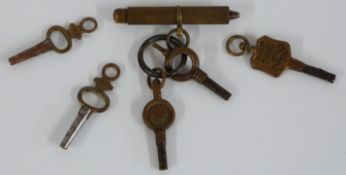 Five pocket watch keys including one stamped Gloucester Street, Stroud