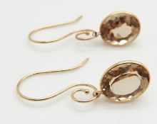 A pair of 14k gold earrings set with oval cut quartz