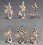 Set of six white metal novelty menu holders formed as people carrying various baskets and