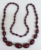 A cherry amber necklace of  52 graduated oval beads, the largest 28.9x26mm, 69g.