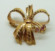 A 18ct gold pendant/ brooch in a bow set with rubies, 6.5g