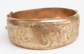 A 9ct gold bangle with engraved foliate decoration, 26g (6.2 x 5.7cm)