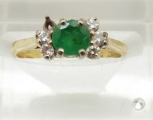 An 18ct gold ring set with a round cut emerald set with diamonds, 2.4g, size I