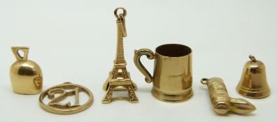 A group of 9ct gold charms including Eiffel Tower, bell, mug, boot and two others, 7.4g
