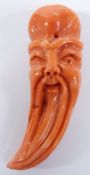 Chinese carved coral figure in the form of a beaded man's head, 4.5cm long.