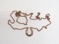 A 9ct gold horseshoe necklace set with diamonds, 27cm drop, 3.4g