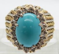 An 18ct gold bi-coloured ring set with a turquoise cabochon surrounded by diamonds, 9.2g, size J