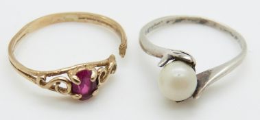 A 9ct gold ring set with a synthetic oval cut ruby and a white metal ring with hands clasping pearl,