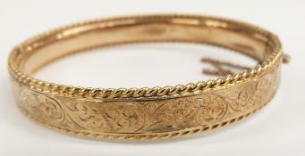 9ct gold bangle with scrolling decoration and rope twist edge, 14.8g, 5.7 x 5cm