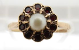 A 9ct gold ring set with a pearl surrounded by garnets, 2g, size M