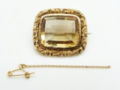 Victorian gold brooch set with a mixed cut citrine within a scrolling border, 10.5g, 3 x 2.6cm