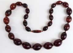 An amber necklace of 27 graduated oval beads, the largest 21.1x16.7, 60g.