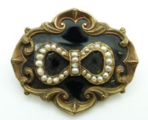 Victorian mourning brooch set with seed pearls to the centre in a bow on black enamel ground within